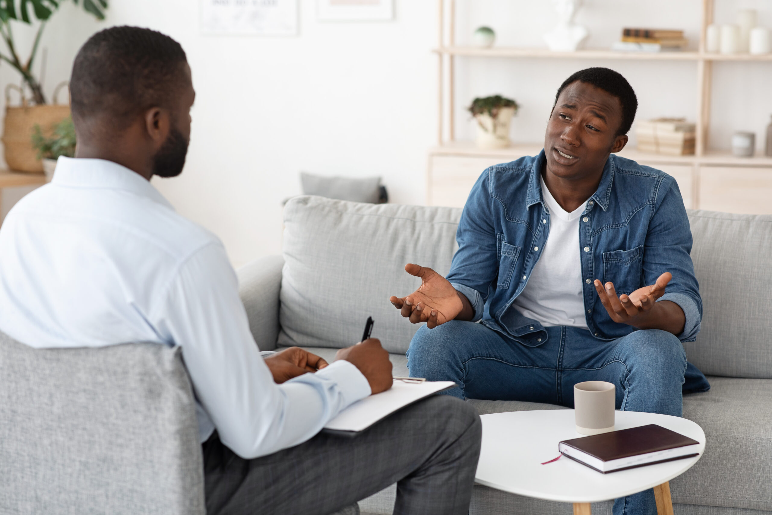Stressed black man explaining his problems to psychologist at individual therapy session Divi-Psychology-img3